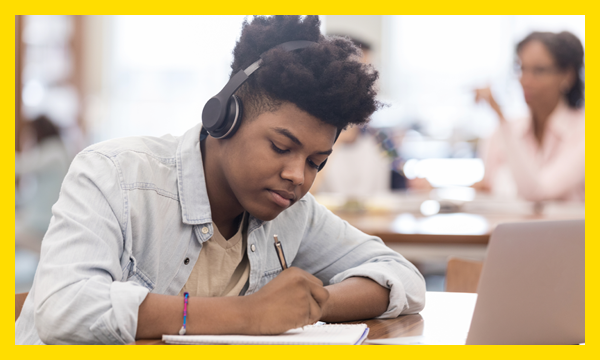 Boy listening to music and writing