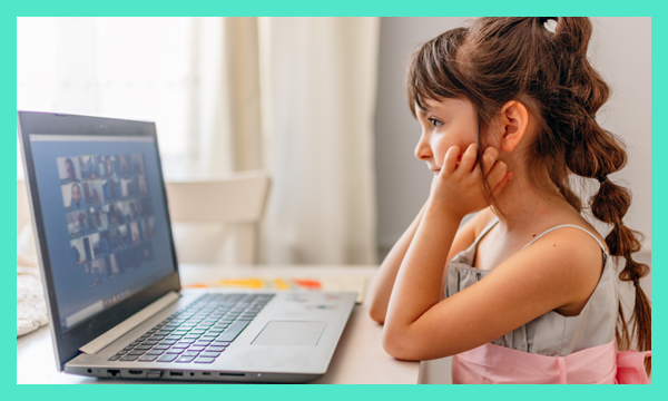 Young child attending virtual lesson on laptop