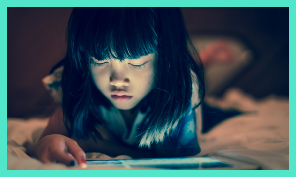 Young child using table in dark setting